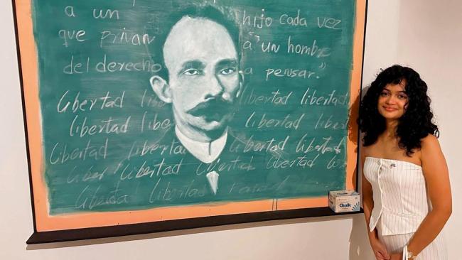 La influencer Anna Bensi junto a una imagen de José Martí.