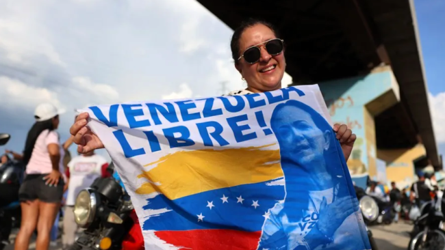 Una mujer espera la llegada de la líder opositora María Corina Machado, en Maracay. 