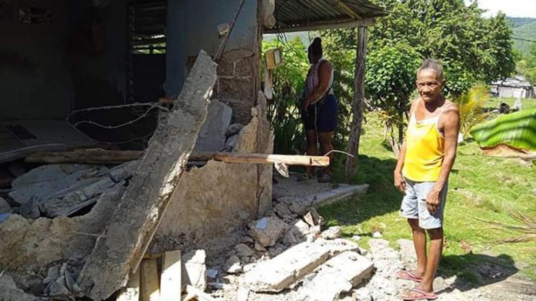 Residentes en Pilón, Granma, entre los restos de su vivienda.