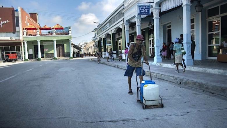 Un hombre carga agua ante la falta de suministro. 