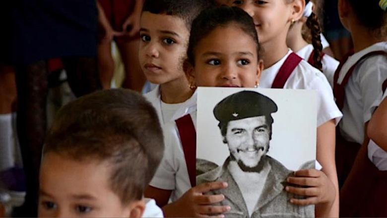 Pioneros cubanos con una imagen del 'Che' Guevara.