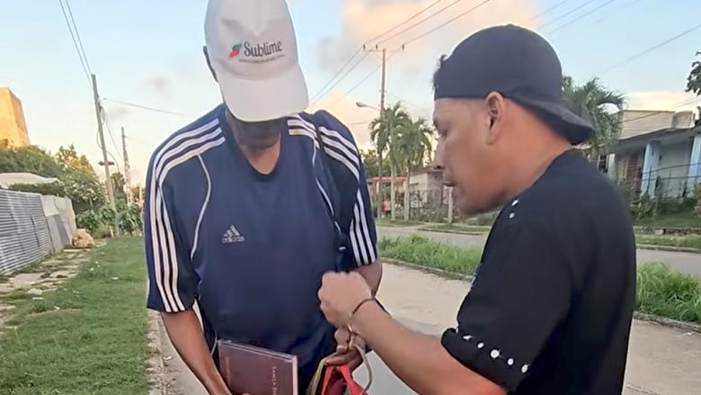 El humorista Limay Blanco entrega comida y una Biblia al tricampeón olímpico de boxeo Félix Savón. (Captura de pantalla)